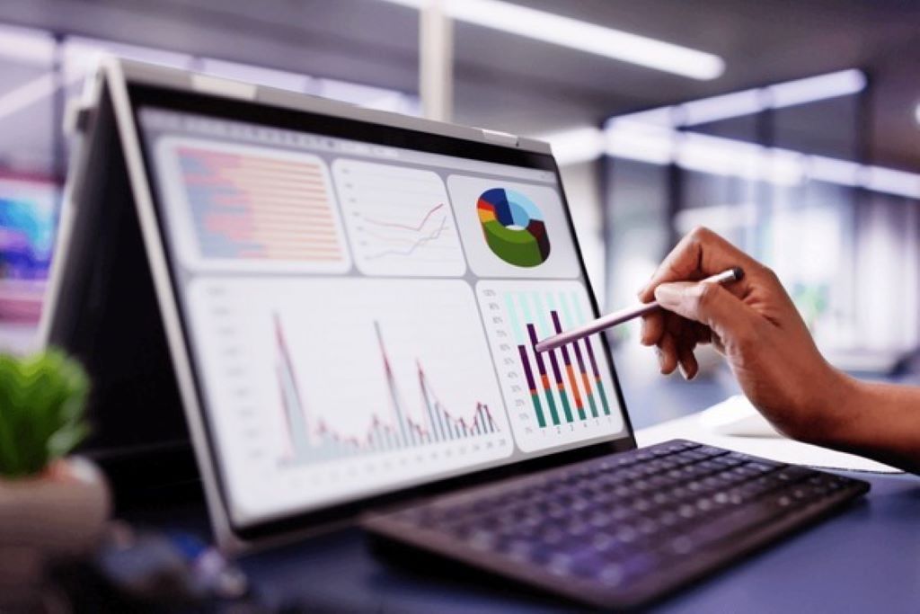 Business team reviewing marketing budget performance data on laptop screen