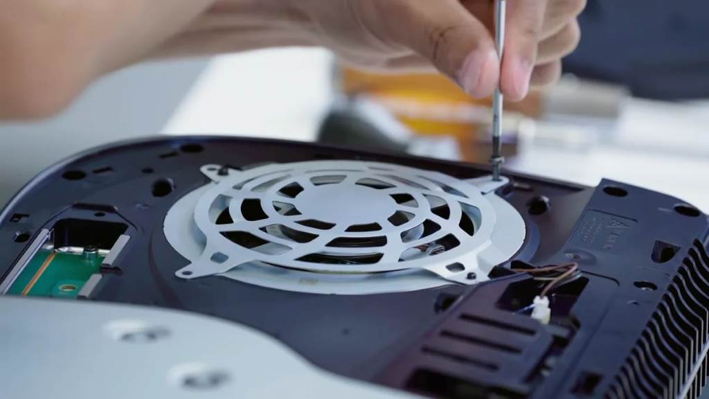 Step-by-step illustration showing compressed air can blasting PS5 fan for noise reduction.