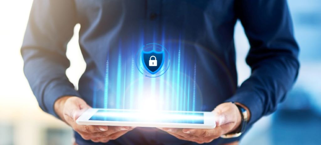 California business protecting digital data from cyber attacks with laptop security shield and network monitoring dashboard.